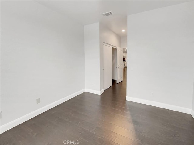 spare room featuring recessed lighting, wood finished floors, visible vents, and baseboards