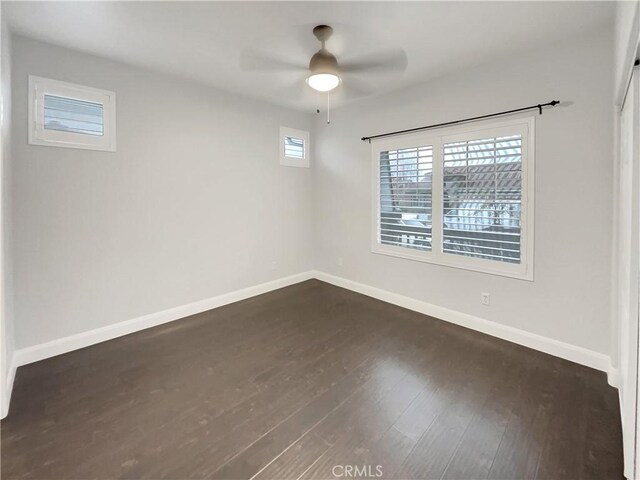 empty room with dark wood-type flooring and ceiling fan