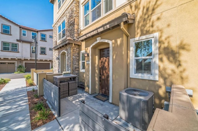 entrance to property with a garage and central air condition unit