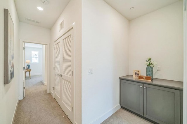 hall featuring light colored carpet