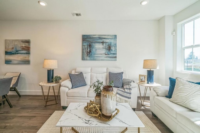 living room with a healthy amount of sunlight and dark hardwood / wood-style flooring