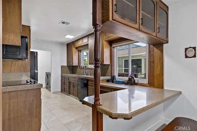 kitchen featuring light tile patterned flooring, kitchen peninsula, sink, a breakfast bar area, and black appliances