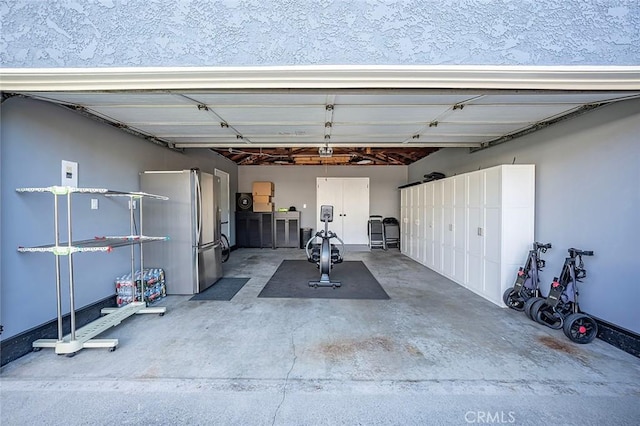 garage featuring a carport, a garage door opener, and stainless steel fridge