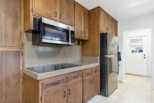 kitchen featuring backsplash, light tile patterned flooring, and appliances with stainless steel finishes