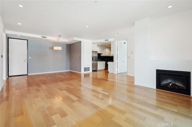 unfurnished living room with light wood-type flooring