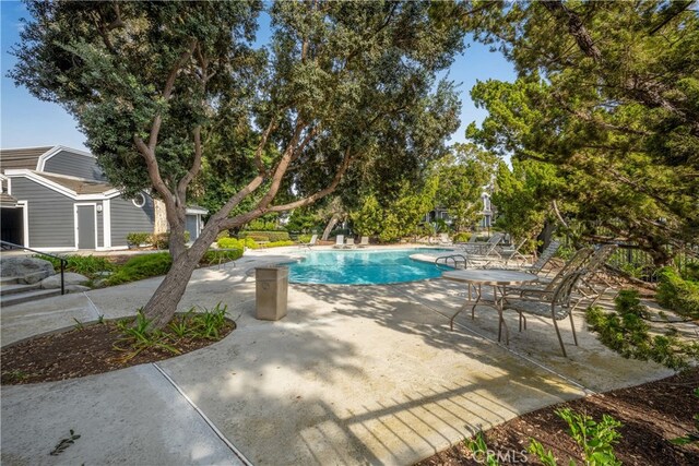 view of pool with an outbuilding and a patio area