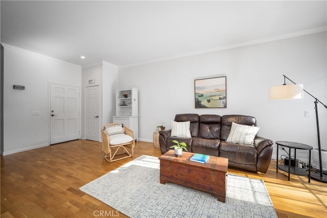 living area with baseboards, wood finished floors, and crown molding