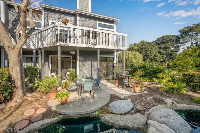 rear view of property featuring a patio area and a chimney