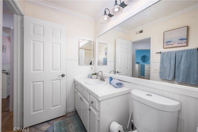 bathroom with vanity, ornamental molding, and toilet