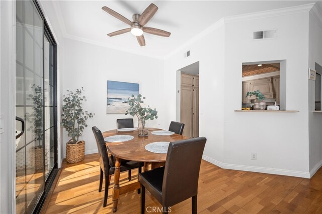 dining area featuring hardwood / wood-style floors, crown molding, and ceiling fan