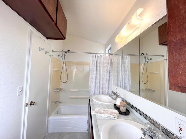 bathroom with tile patterned floors, vaulted ceiling, shower / bath combo with shower curtain, and vanity