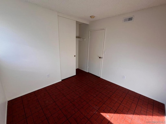 unfurnished room featuring a textured ceiling