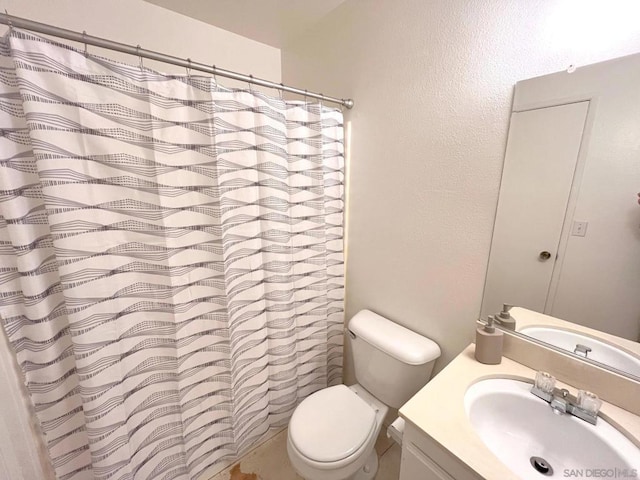 bathroom with vanity, curtained shower, and toilet