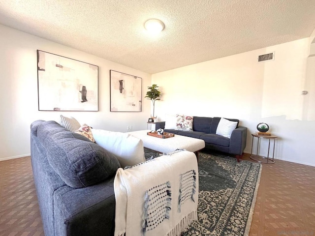 living room featuring carpet and a textured ceiling