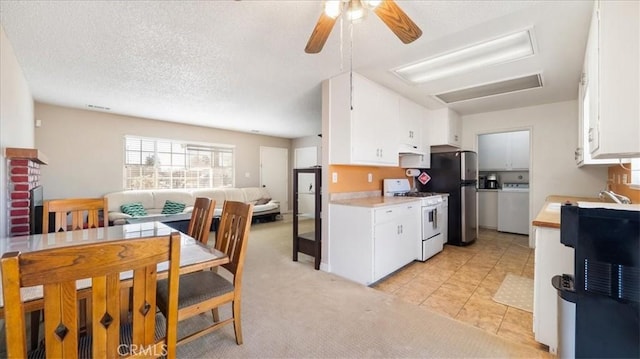 kitchen featuring white cabinetry, sink, washer / dryer, and white gas range oven