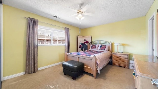 bedroom featuring ceiling fan, light colored carpet, and a textured ceiling