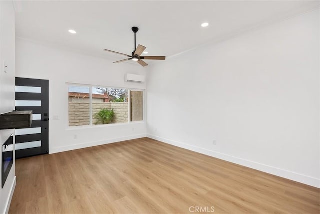 unfurnished living room featuring ceiling fan, a wall unit AC, and light hardwood / wood-style floors