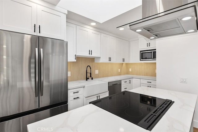 kitchen featuring sink, appliances with stainless steel finishes, light stone counters, white cabinets, and island exhaust hood