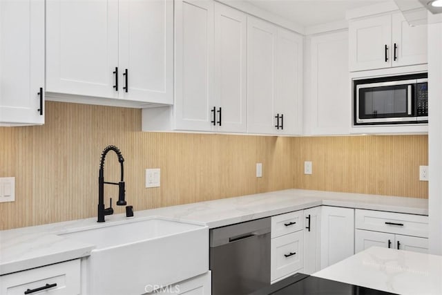 kitchen featuring light stone countertops, appliances with stainless steel finishes, sink, and white cabinets