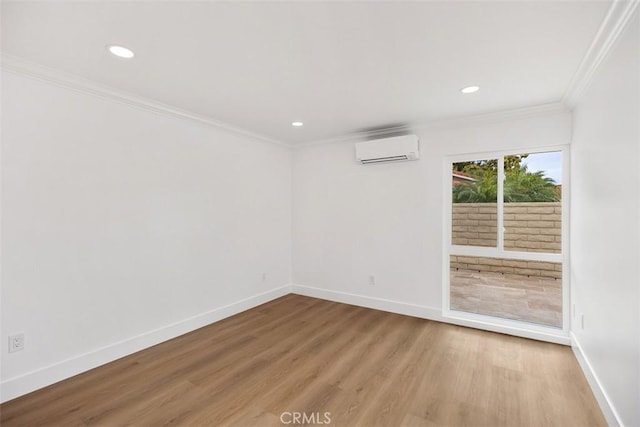 spare room featuring hardwood / wood-style flooring, crown molding, and an AC wall unit