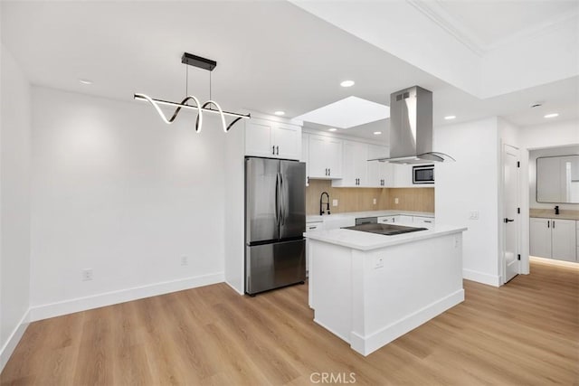 kitchen featuring pendant lighting, island range hood, white cabinets, stainless steel appliances, and light hardwood / wood-style flooring