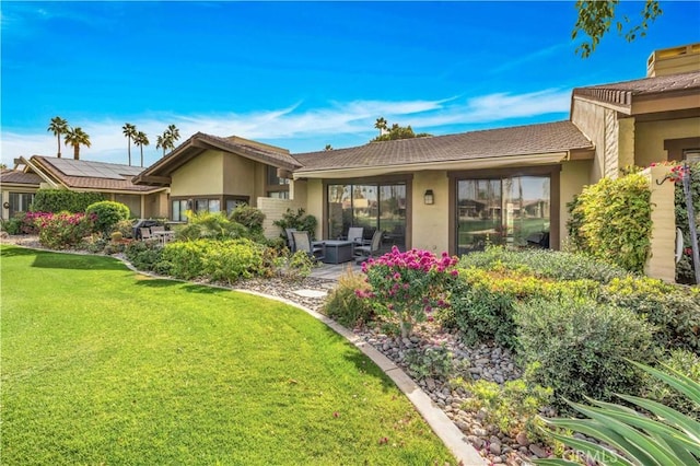 rear view of house with a patio area and a lawn