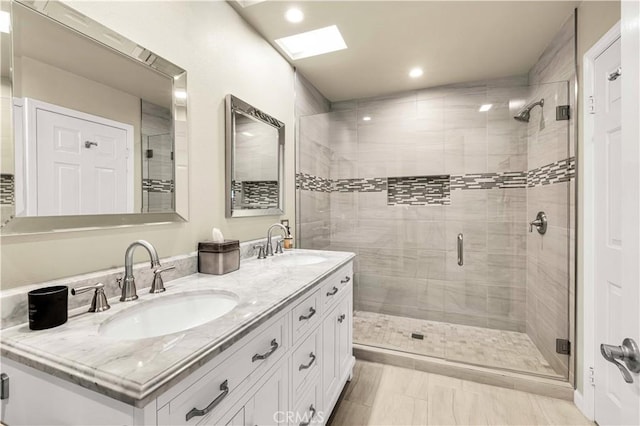 bathroom with walk in shower, vanity, and a skylight