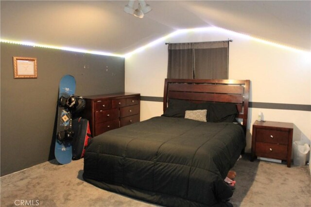 bedroom with vaulted ceiling and light colored carpet