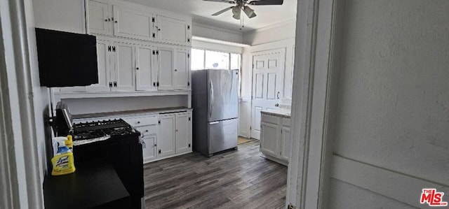 kitchen with dark hardwood / wood-style floors, stainless steel refrigerator, white cabinetry, black range with gas stovetop, and ceiling fan