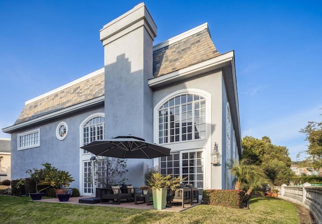 rear view of house with french doors, a yard, and a patio area