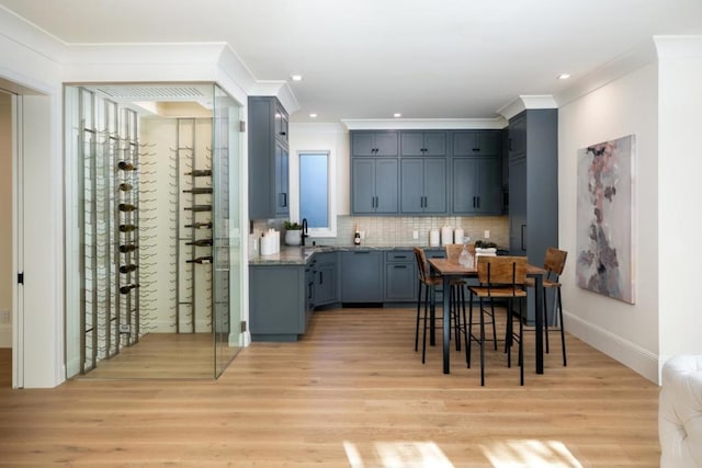 dining room with crown molding and light wood-type flooring