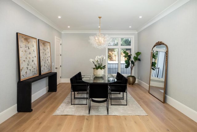 dining space featuring crown molding, a chandelier, and light hardwood / wood-style floors