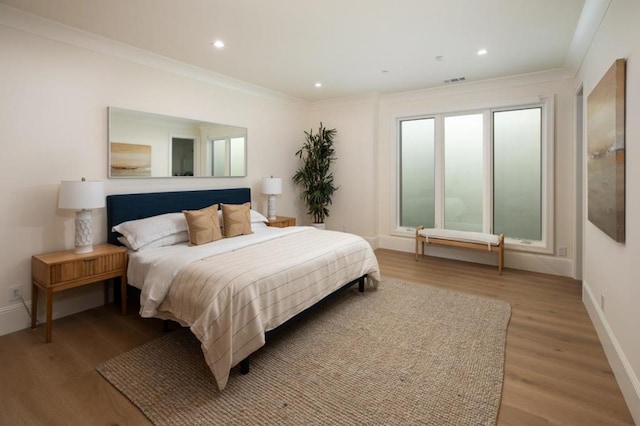 bedroom with crown molding and light hardwood / wood-style floors