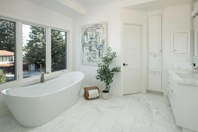 bathroom featuring vanity, crown molding, and a tub