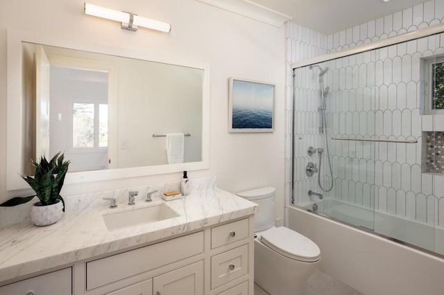 full bathroom with vanity, shower / bath combination with glass door, and toilet