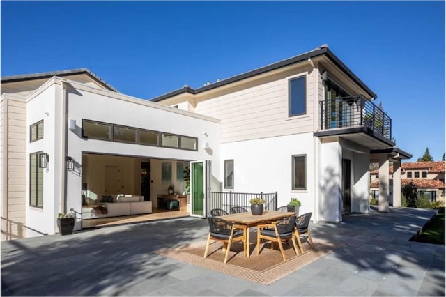 back of property with a balcony and a patio area