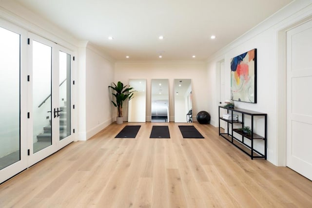 interior space with ornamental molding, light wood-type flooring, and french doors