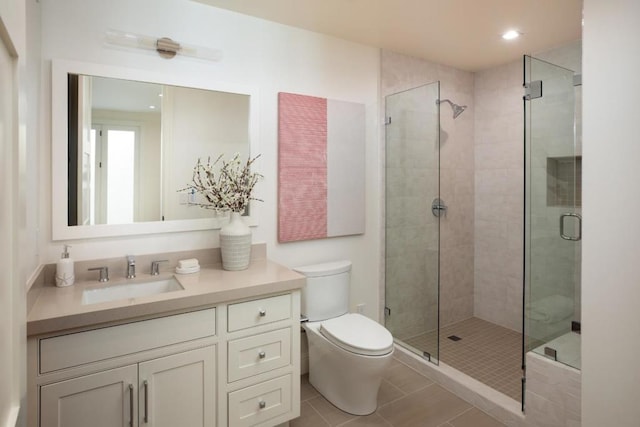 bathroom featuring tile patterned flooring, vanity, an enclosed shower, and toilet