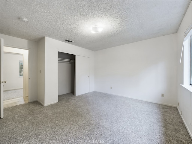 unfurnished bedroom with a closet, a textured ceiling, and carpet flooring