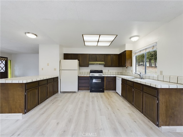 kitchen featuring sink, white appliances, light hardwood / wood-style flooring, dark brown cabinetry, and kitchen peninsula