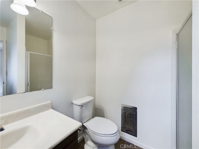 bathroom with walk in shower, vanity, and toilet