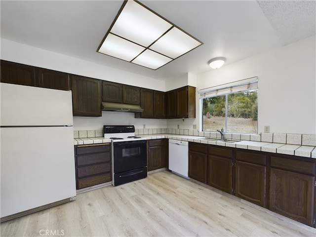 kitchen with sink, white appliances, dark brown cabinets, and light wood-type flooring