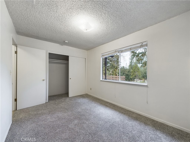 unfurnished bedroom featuring carpet flooring, a closet, and a textured ceiling