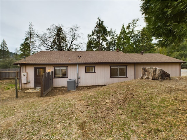 back of house featuring a lawn and central air condition unit