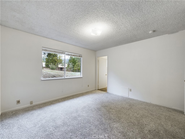 unfurnished room with carpet and a textured ceiling