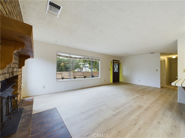 living room with light hardwood / wood-style floors and a textured ceiling