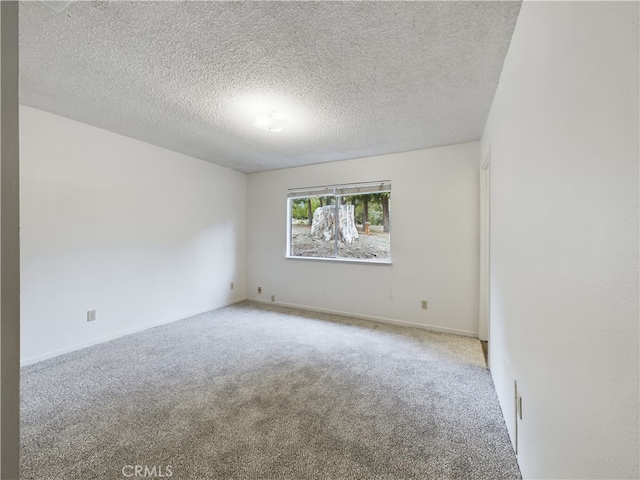 carpeted spare room with a textured ceiling