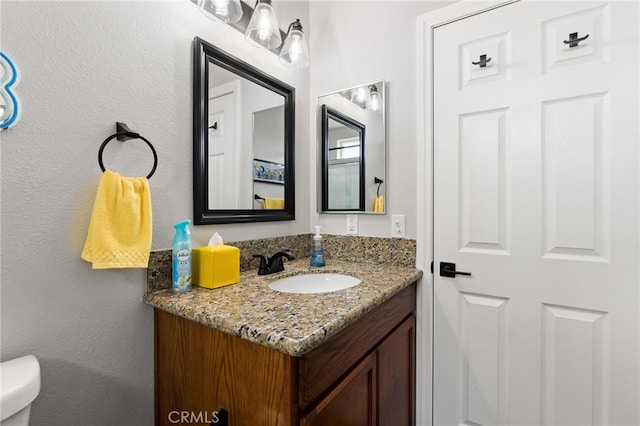 bathroom featuring vanity and toilet