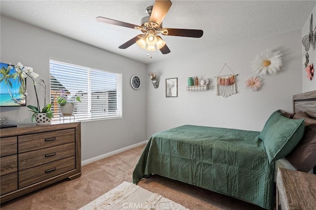 carpeted bedroom with a textured ceiling and ceiling fan