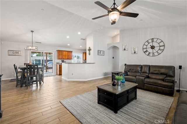 living room featuring vaulted ceiling, ceiling fan, and light hardwood / wood-style floors